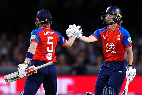 England's Amy Jones, right, celebrates making 50 runs with batting partner Heather Knight, left, during the first Vitality IT20 cricket match between England and India in Chelmsford, England.