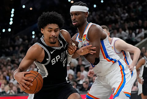 San Antonio Spurs guard Dylan Harper (2) drives against Oklahoma City Thunder guard Shai Gilgeous-Alexander (2) in the first half of Game 6 in the Western Conference finals NBA basketball playoffs series, in San Antonio.