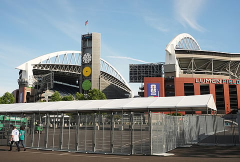 People walk by Lumen Field, which will be named Seattle Stadium during the 2026 FIFA World Cup, as fencing goes up around the perimeter, in Seattle. 