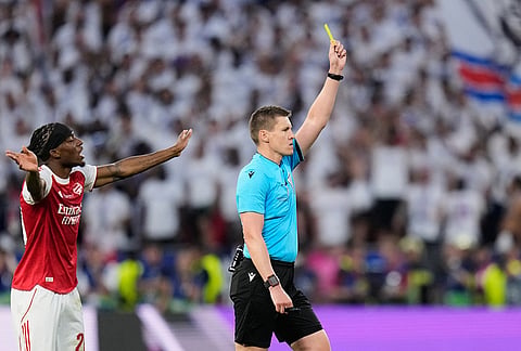 Arsenal's Noni Madueke gestures as Referee Daniel Siebert a yellow card to Arsenal's Declan Rice during the Champions League final soccer match between Paris Saint-Germain and Arsenal in Budapest, Hungary.