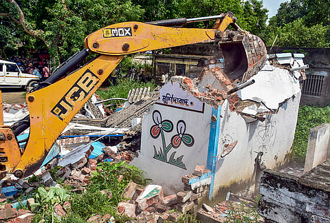 A bulldozer demolishes a TMC party office during a demolition drive carried out by the Railway department near Beldanga railway station, in Murshidabad district, West Bengal.
