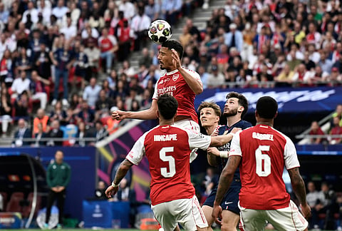 Arsenal's William Saliba, top, heads the ball during the Champions League final soccer match between Paris Saint-Germain and Arsenal in Budapest, Hungary.