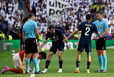 Referee Daniel Siebert, right, discusses with PSG's Achraf Hakimi during the Champions League final soccer match between Paris Saint-Germain and Arsenal in Budapest, Hungary.
