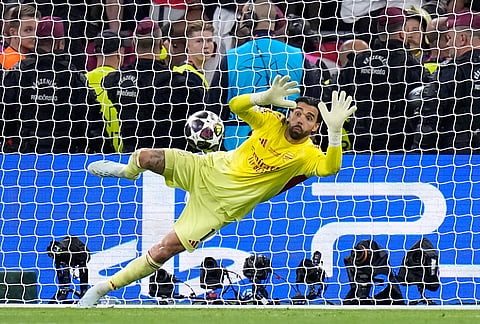 Arsenal's goalkeeper David Raya saves a shot from PSG's Nuno Mendes during a penalty shootout after extra time during the Champions League final soccer match between Paris Saint-Germain and Arsenal in Budapest, Hungary.