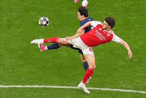 Arsenal's Declan Rice, right, challenges for the ball with PSG's Vitinha during the Champions League final soccer match between Paris Saint-Germain and Arsenal in Budapest, Hungary.
