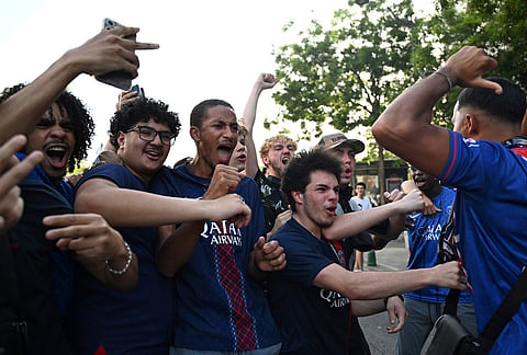 PSG supporters react as they gather in Paris, while the Champions League final soccer match between Paris Saint-Germain and Arsenal is being played in Budapest. 