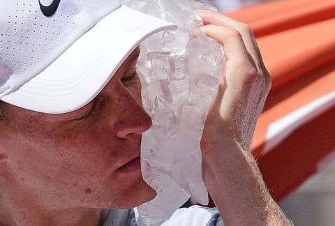 Jannik Sinner of Italy cools himself with the ice during the second round men's singles tennis match against Juan Manuel Cerundolo of Argentina at the French Open tennis tournament in Paris.