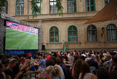 Fans watch on TV the Champions League final soccer match between Paris Saint-Germain and Arsenal in a bar in Budapest, Hungary.