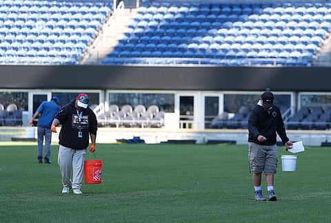 Workers sprinkle extra grass seeds on the field as preparations continue at Seattle Stadium, normally known as Lumen Field, ahead of the 2026 FIFA World Cup matches, in Seattle. 