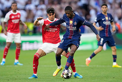 Arsenal's Piero Hincapie vies for the ball with PSG's Ousmane Dembele, right, during the Champions League final soccer match between Paris Saint-Germain and Arsenal in Budapest, Hungary.