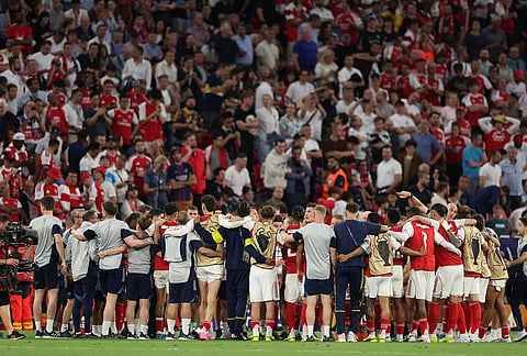 Arsenal players huddle before the penalty shoot out during the Champions League final soccer match between Paris Saint-Germain and Arsenal in Budapest, Hungary.
