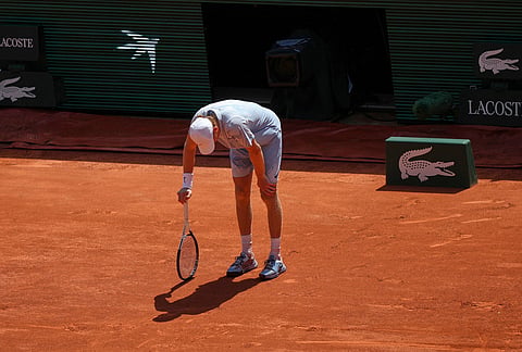 Jannik Sinner of Italy reacts as he feels unwell because of the heat during the second round men's singles tennis match against Juan Manuel Cerundolo of Argentina at the French Open tennis tournament in Paris, as temperature rises up to 33 C (91 F). 