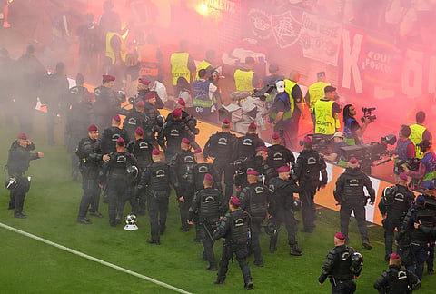 Police try to prevent fans from occupying the pitch during the Champions League final soccer match between Paris Saint-Germain and Arsenal in Budapest, Hungary.