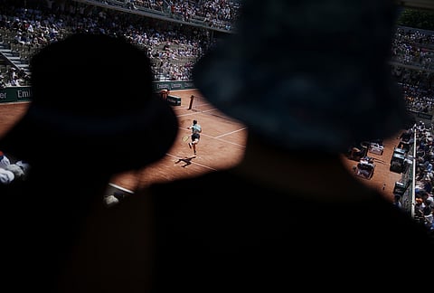 Visitors watch as Camilo Ugo Carabelli of Argentina serves to Andrey Rublev of Russia during their second round men's singles tennis match at the French Open tennis tournament in Paris.