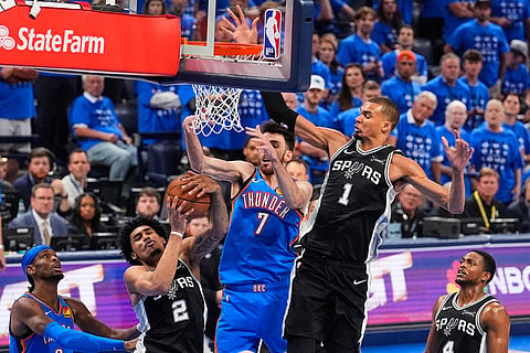 Oklahoma City Thunder center Chet Holmgren (7) battles under the basket between San Antonio Spurs guard Dylan Harper (2) and forward Victor Wembanyama (1) in the second half of Game 7 of the Western Conference finals of the NBA basketball playoffs series in Oklahoma City.