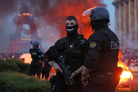 A car burns and fireworks explode as police watch PSG supporters celebrate in Paris, Saturday, May 30, 2026 after the Champions League final soccer match between Paris Saint-Germain and Arsenal that's being played in Budapest. PSG won the game.
