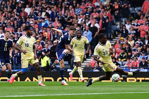 Scotland's Findlay Curtis, center, scores during an international friendly match between Scotland and Curacao in Glasgow.