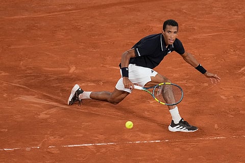 Felix Auger-Aliassime of Canada returns to Brandon Nakashima of the U.S. during their third round men's singles tennis match at the French Open tennis tournament in Paris.