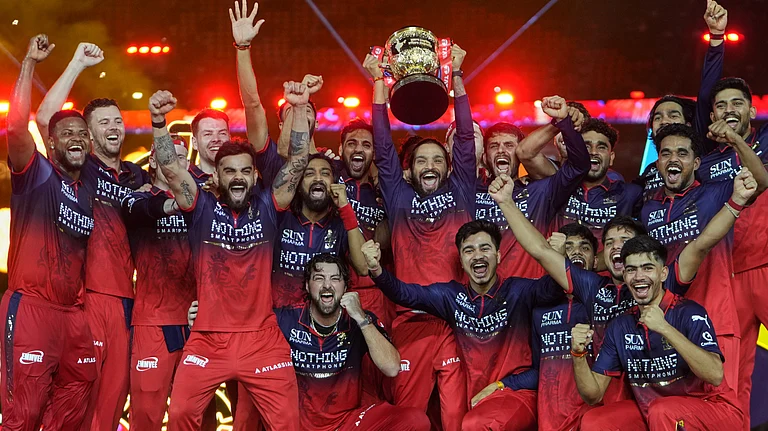 Royal Challengers Bengaluru players celebrate with winners trophy after their win in the Indian Premier League final cricket match against Gujarat Titans in Ahmedabad. - AP Photo