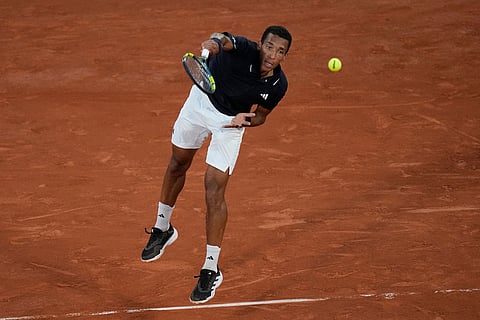Felix Auger-Aliassime of Canada serves to Brandon Nakashima of the U.S. during their third round men's singles tennis match at the French Open tennis tournament in Paris.