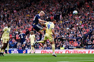 | Photo: Andrew Milligan/PA via AP : Scotland's George Hirst, left, and Curacao's Armando Obispo in action during an international friendly match between Scotland and Curacao in Glasgow.