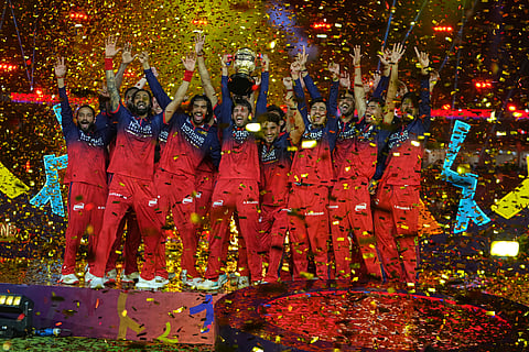 Royal Challengers Bengaluru players celebrate with winners trophy after their win in the Indian Premier League final cricket match against Gujarat Titans in Ahmedabad.