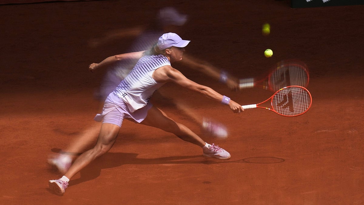 Iga Swiatek of Poland is reflected in a glass as she returns to Magda Linette of Poland during their third round women's singles tennis match at the French Open tennis tournament in Paris, Friday, May 29, 2026. - (AP Photo/Christophe Ena)