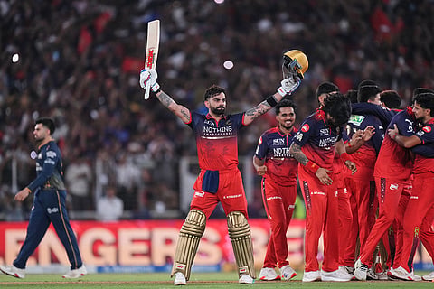 Royal Challengers Bengaluru's Virat Kohli celebrates with teammates after their win in the Indian Premier League final cricket match against Gujarat Titans in Ahmedabad, India.