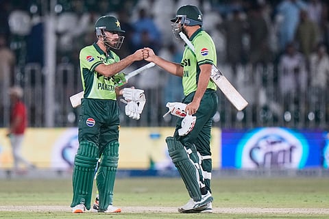 Pakistan's Arafat Minhas, left, and Abdul Samad celebrates after winning the first one day international cricket match against Australia, in Rawalpindi, Pakistan.