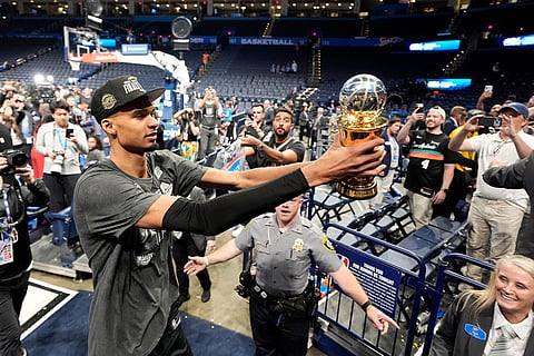 San Antonio Spurs forward Victor Wembanyama walks over to Spurs fans as he holds his MVP trophy as he celebrates after Game 7 of the Western Conference finals of the NBA basketball playoffs series win against the Oklahoma City Thunder in Oklahoma City.