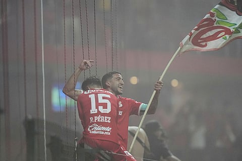 Toluca's Nicolás Castro, right, and Pavel Perez celebrate after winning the CONCACAF Champions Cup final soccer match against Tigres in Toluca, Mexico.