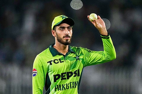 Pakistan's Arafat Minhas, who took five wickets, displays the ball as he walks off the field on the end of first innings during the first one day international cricket match between Pakistan and Australia, in Rawalpindi, Pakistan.
