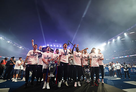 PSG players celebrate with the trophy at Parc des Princes stadium, in Paris during a special event organized to celebrate with supporters after their victory over Arsenal FC in the UEFA Champions League soccer final.