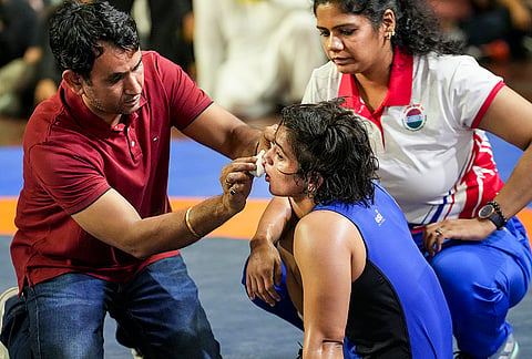 Wrestler Meenakshi Goyat is attended by officials after an injury during the women's 53kg category final wrestling match against Antim Panghal at the Asian Games selection trials, in New Delhi.