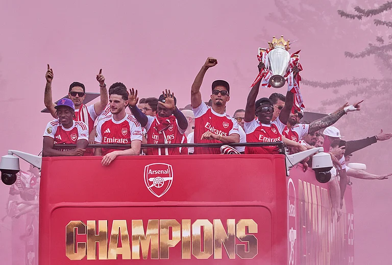 Arsenal's Bukayo Saka, right, lifts the trophy during a parade for winning the English Premier League title, in London. - | Photo: AP/Kin Cheung