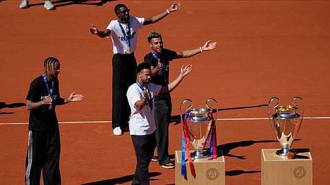 Paris Saint-Germain players Bradley Barcola, left. Warren Zaire-Emery, center, Desire Doue, right, and Ousmane Dembele present two Champions League trophies at the French Open in Paris, Monday, June 1, 2026.