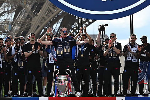 PSG's players celebrate the day after winning the Champions League title, at the Eiffel Tower, in Paris.