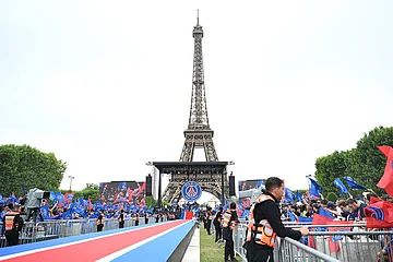 | Photo: AP/Emma Da Silva : Security and fans wait for PSG's players to arrive and celebrate, the day after winning the Champions League title, at the Eiffel Tower, in Paris.