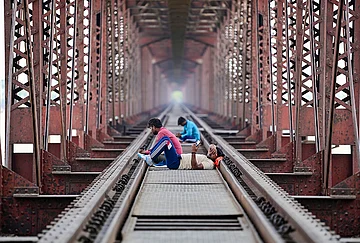 | Photo: PTI : Prayagraj: People rest on the railway track of the Lord Curzon Bridge over River Ganga on a hot summer day, in Prayagraj.