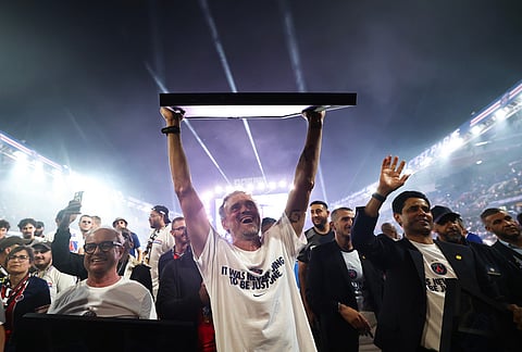 Paris Saint-Germain's head coach Luis Enrique celebrates at Parc des Princes stadium, in Paris during a special event organized to celebrate with supporters after their victory over Arsenal FC in the UEFA Champions League soccer final. 