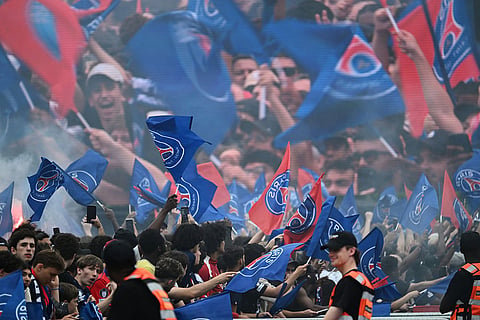 PSG fans celebrate the day after winning the Champions League title, at the Eiffel Tower, in Paris.