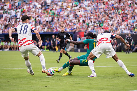 Senegal defender Cherif Ndiaye (12) loses his footing against United States defender Auston Trusty, right, and forward Max Arfsten (18) during the second half of an international friendly soccer match in Charlotte, N.C.