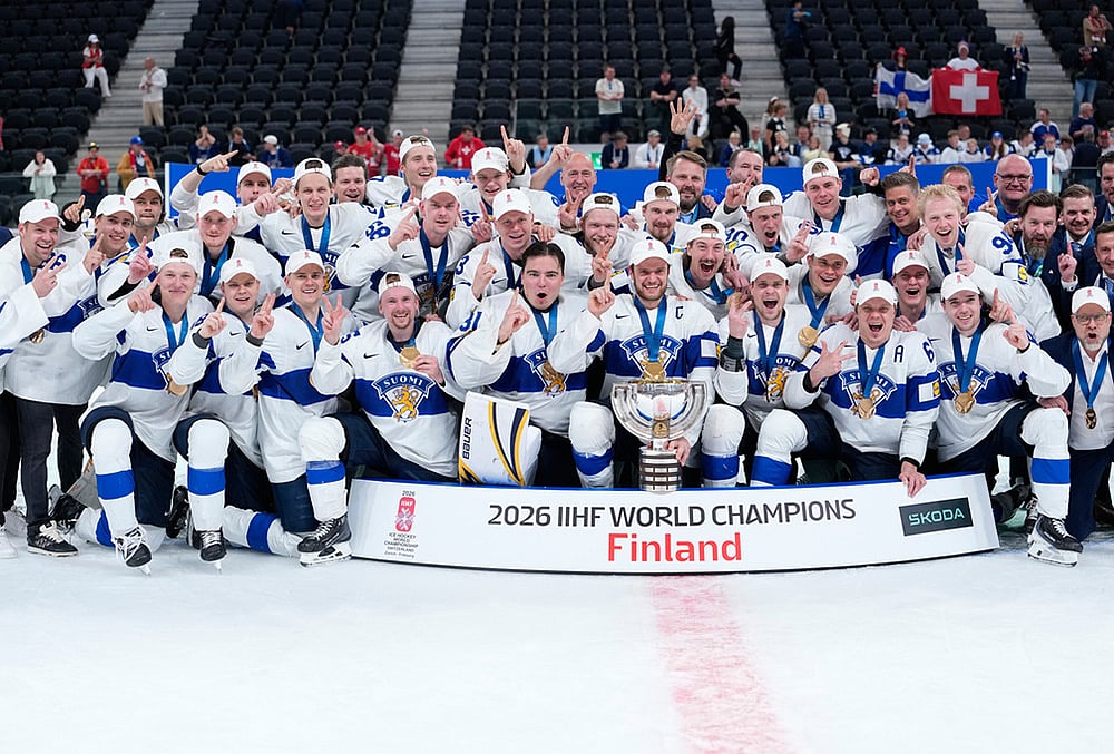 Finland players celebrate with trophy after winning the 2026 IIHF Men's Ice Hockey World Championship final match against Switzerland, in Zurich, Switzerland. - | Photo: AP/Darko Bandic
