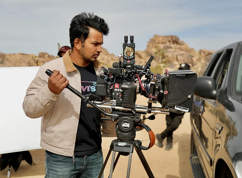 Man operating a professional cinema camera outdoors