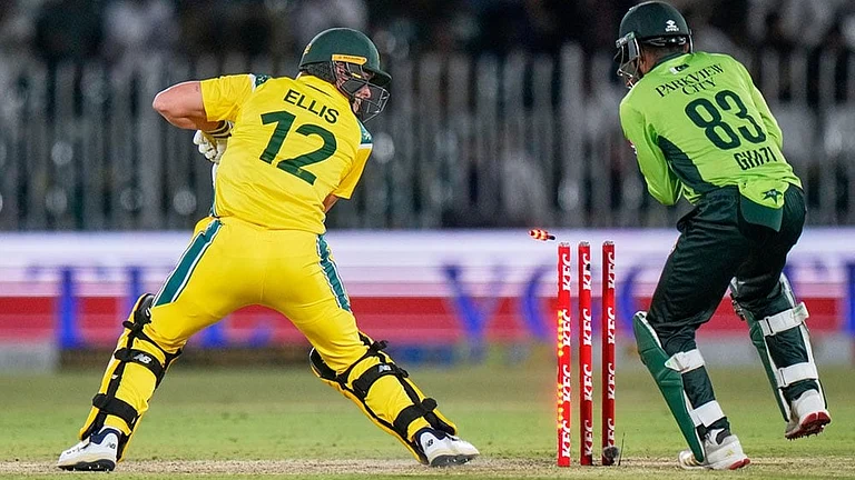 Australia's Nathan Ellis, left, looks wickets after he is bowled out by Pakistan's Arafat Minhas during the first One Day International cricket match between Pakistan and Australia, in Rawalpindi, Pakistan. - | Photo: AP/Anjum Naveed