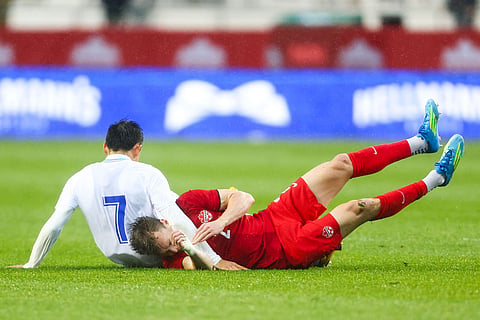 Canada's Alistair Johnston, right, is tackled by Uzbekistan's Otabek Shukurov (7) during the first half of an international friendly soccer match in Edmonton, Alberta, Monday, June 1, 2026. ()