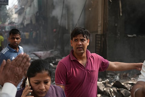 A person pleads with rescuers to save a relative trapped inside a hotel fire in New Delhi, India.
