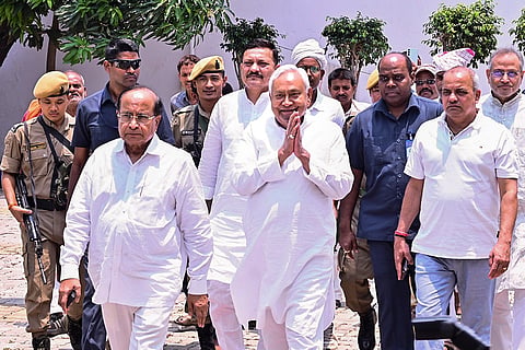 JDU National President Nitish Kumar greets the gathering as he leaves the party office after a meeting, in Patna, Bihar.