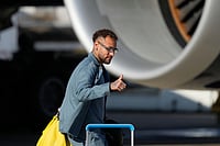 | Photo: AP/Seth Wenig : Brazilian soccer player Neymar gives a thumbs up as he disembarks at Newark Liberty International Airport in Newark, N.J., as the team arrives ahead of the World Cup soccer tournament.