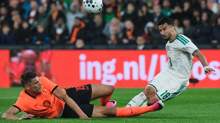 Netherlands' Micky van de Ven, left, challenges for the ball with Algeria's Mohammed Amoura during the international friendly soccer match between Netherlands and Algeria in Rotterdam, Netherlands. - AP Photo